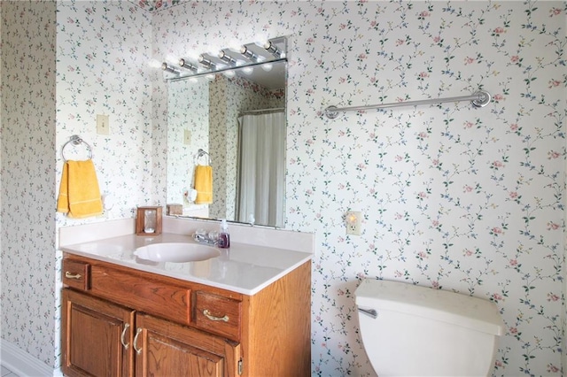 bathroom featuring walk in shower, vanity, and toilet