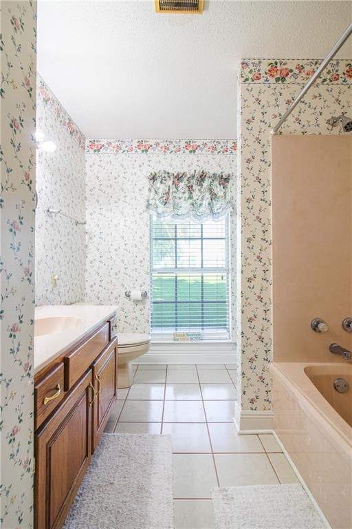 full bathroom featuring tiled shower / bath, vanity, toilet, and tile patterned floors