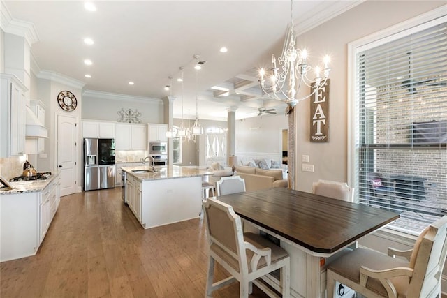 dining area with coffered ceiling, ceiling fan, hardwood / wood-style flooring, ornamental molding, and sink