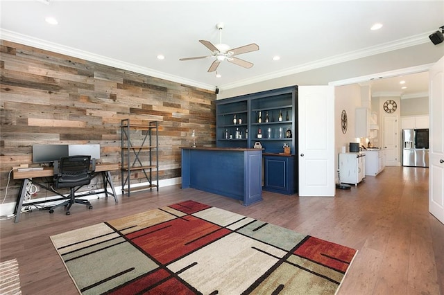 interior space with wood walls, ornamental molding, dark hardwood / wood-style floors, and ceiling fan