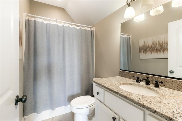 bathroom featuring vanity, tile patterned flooring, vaulted ceiling, and toilet