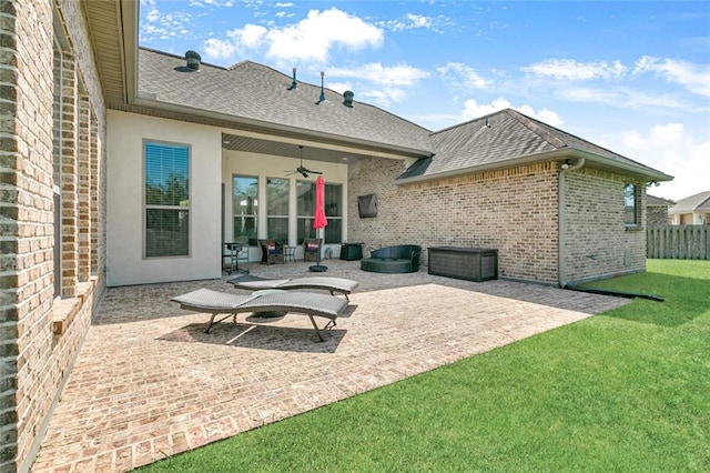 back of property featuring a yard, ceiling fan, and a patio area