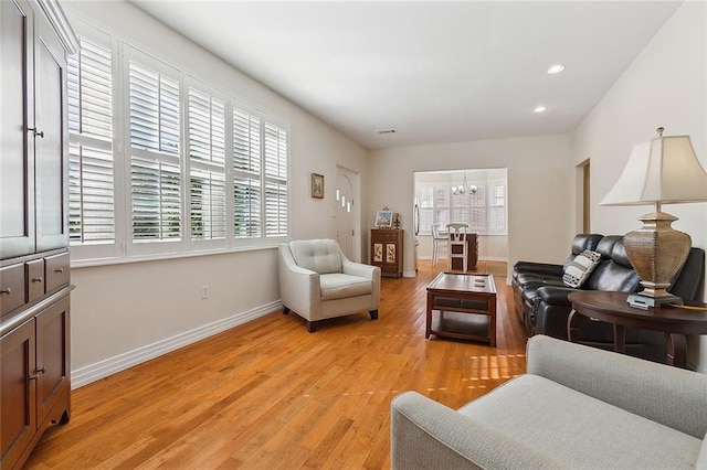 living room with light hardwood / wood-style flooring and a chandelier