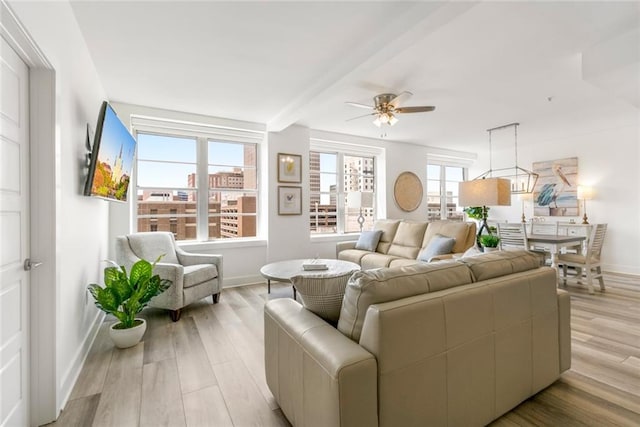 living room featuring beam ceiling, ceiling fan, and light hardwood / wood-style flooring