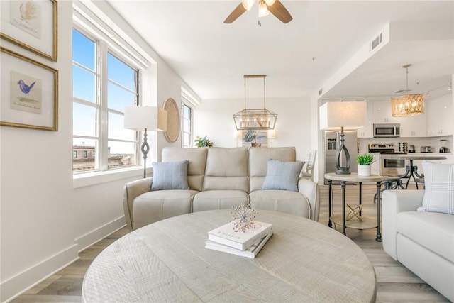 living room featuring ceiling fan and light hardwood / wood-style floors