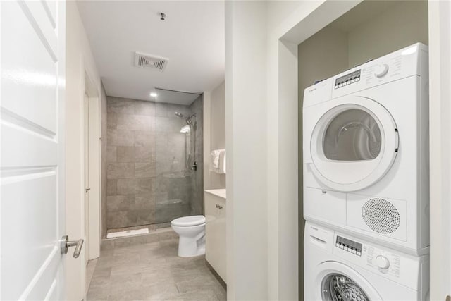 laundry room with stacked washing maching and dryer