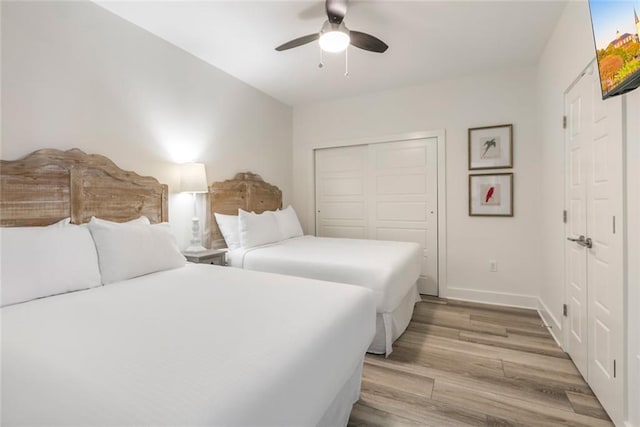 bedroom featuring light hardwood / wood-style floors, ceiling fan, and a closet