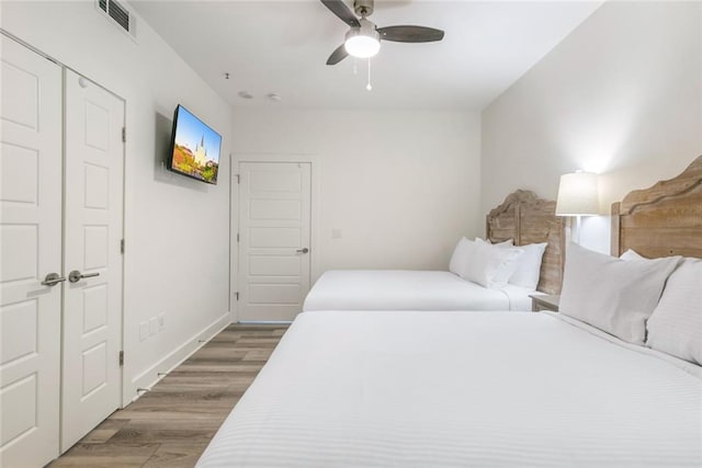 bedroom featuring hardwood / wood-style floors, ceiling fan, and a closet