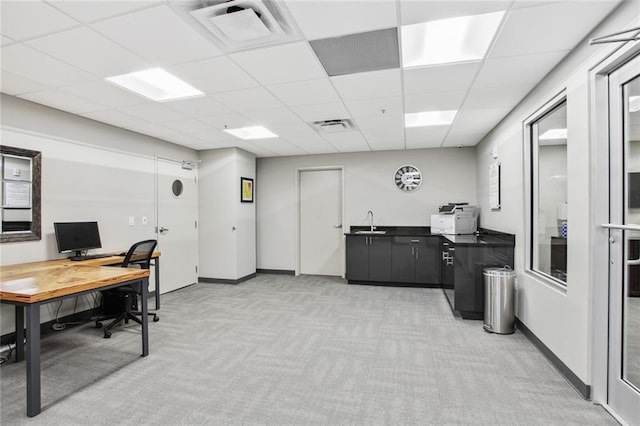 home office featuring light carpet, a drop ceiling, and sink