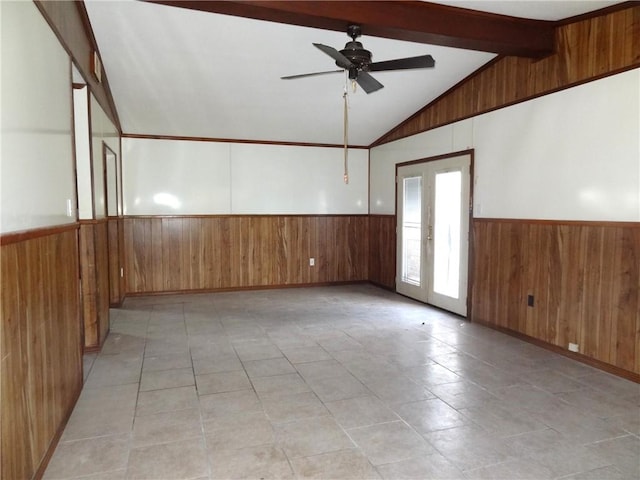 empty room featuring french doors, wooden walls, and lofted ceiling with beams