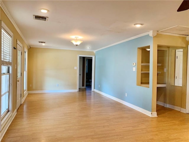 empty room with light wood-type flooring and crown molding