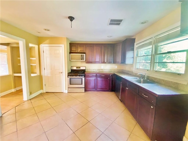 kitchen featuring light tile patterned floors, stainless steel appliances, and sink