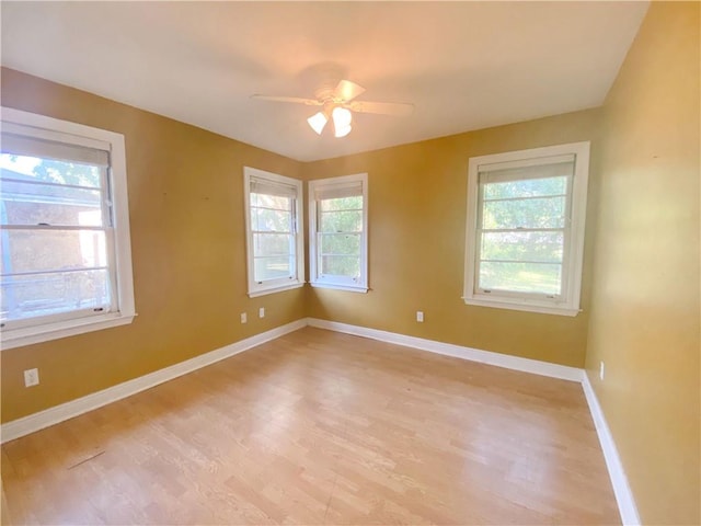 empty room featuring ceiling fan, light hardwood / wood-style floors, and a wealth of natural light