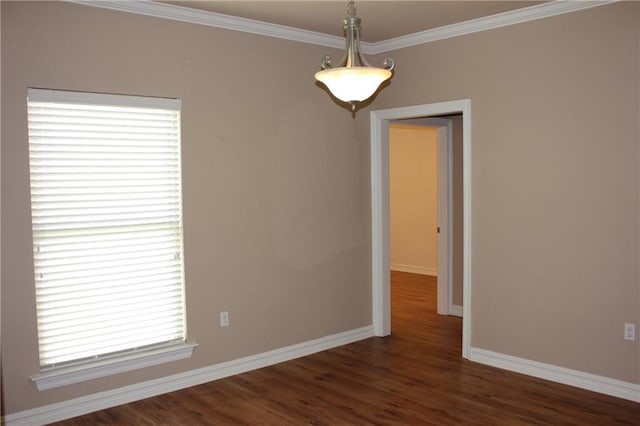 empty room with dark wood finished floors, baseboards, and ornamental molding