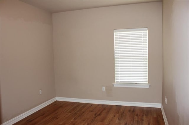 unfurnished room with baseboards and wood finished floors
