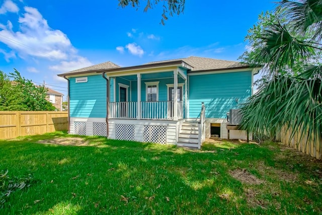 back of house featuring a yard and covered porch