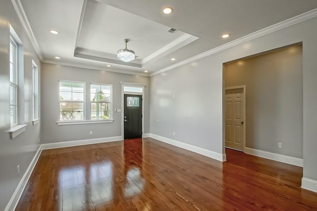 interior space featuring ornamental molding, dark hardwood / wood-style flooring, and a tray ceiling