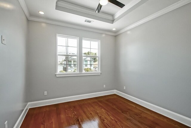 spare room with ceiling fan, hardwood / wood-style flooring, a tray ceiling, and ornamental molding