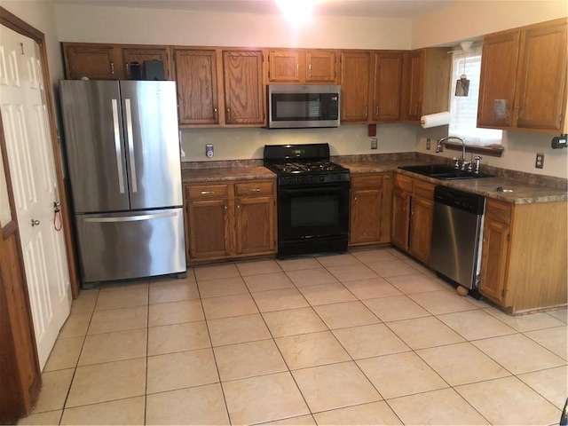 kitchen featuring appliances with stainless steel finishes, sink, and light tile patterned floors