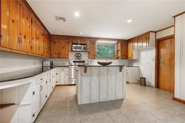 kitchen featuring a center island, appliances with stainless steel finishes, and light tile patterned flooring