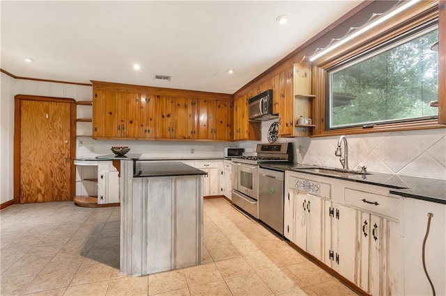 kitchen featuring appliances with stainless steel finishes, wood walls, sink, and a kitchen island