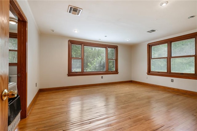 spare room with heating unit, light hardwood / wood-style flooring, and crown molding