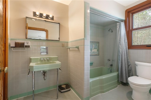 full bathroom with sink, tile walls, toilet, and shower / bath combo