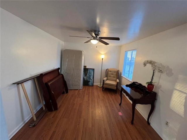 sitting room featuring ceiling fan and dark wood-type flooring