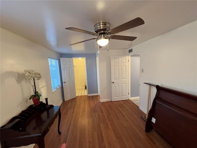 unfurnished bedroom featuring dark wood-type flooring and ceiling fan