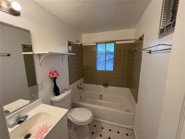 full bathroom featuring tiled shower / bath combo, vanity, and toilet