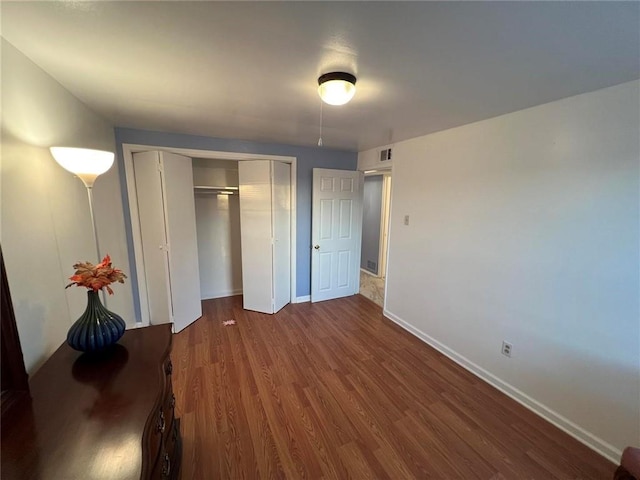 unfurnished bedroom featuring dark hardwood / wood-style flooring and a closet