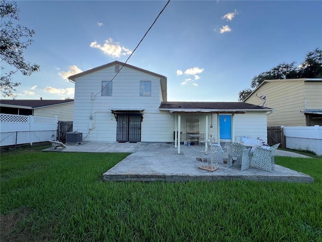 rear view of house featuring a patio area, central air condition unit, and a yard