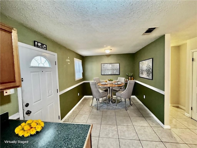 tiled dining space featuring a textured ceiling