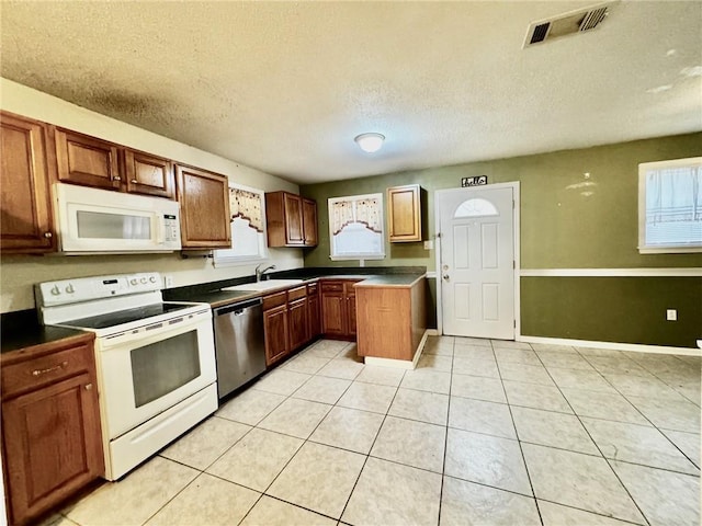 40735 Chinchas Creek Rd, Slidell, LA 70461 - kitchen with white appliances, dark countertops, light tile patterned floors, a textured ceiling, and a sink