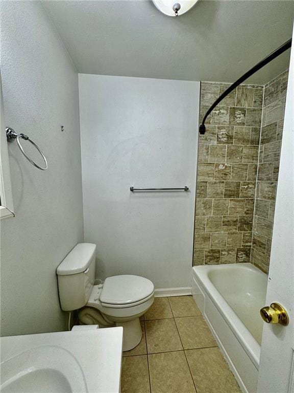 bathroom featuring toilet, tiled shower / bath combo, and tile patterned floors