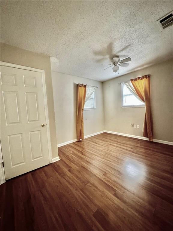 unfurnished room featuring hardwood / wood-style flooring, ceiling fan, and a textured ceiling