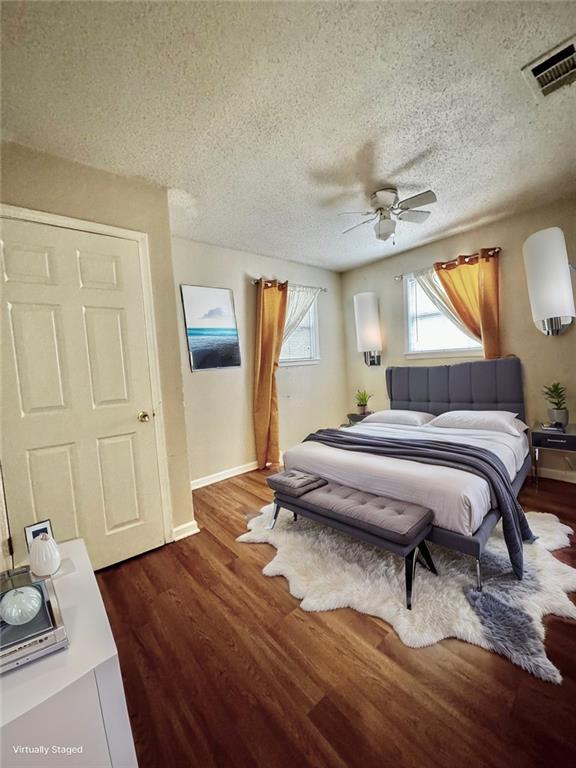 bedroom featuring a textured ceiling, ceiling fan, and dark hardwood / wood-style floors