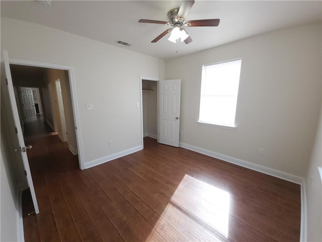 unfurnished bedroom with ceiling fan and dark hardwood / wood-style flooring