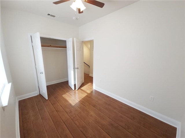 unfurnished bedroom with wood-type flooring, a closet, and ceiling fan