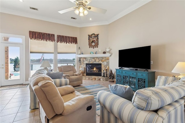 tiled living room with a fireplace, ceiling fan, and ornamental molding