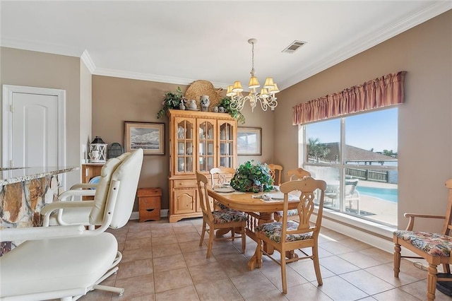 dining room with light tile patterned floors, ornamental molding, and a notable chandelier