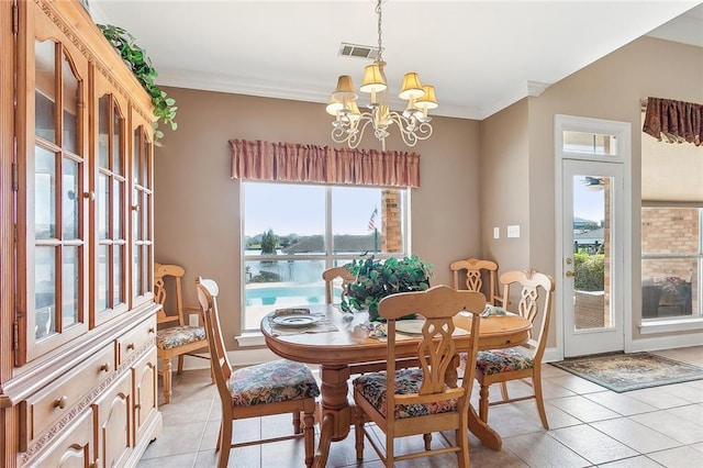 tiled dining room with plenty of natural light, a water view, ornamental molding, and an inviting chandelier