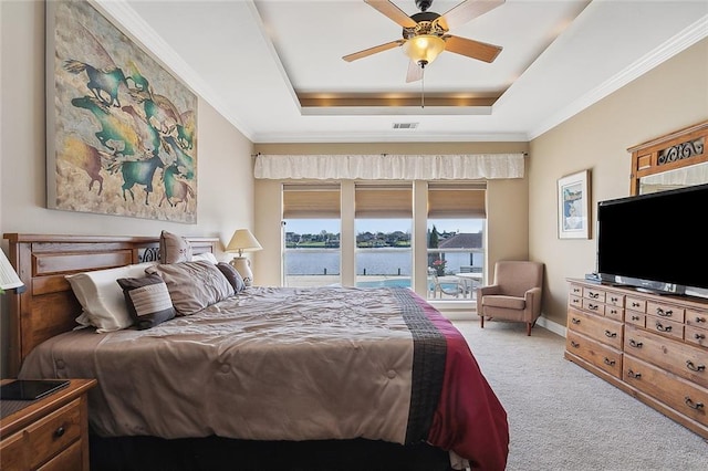 carpeted bedroom with ceiling fan and a tray ceiling