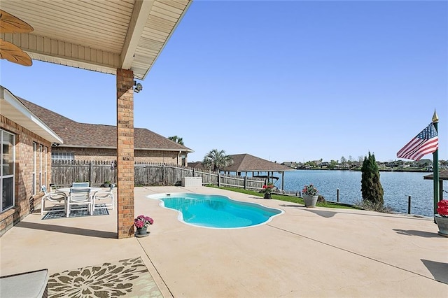 view of swimming pool with a patio area and a water view