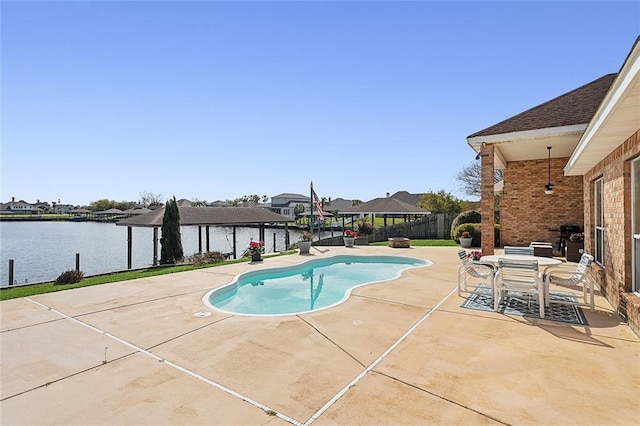 view of pool with a water view and a patio