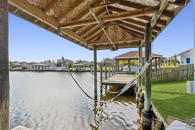 view of dock with a water view and a yard