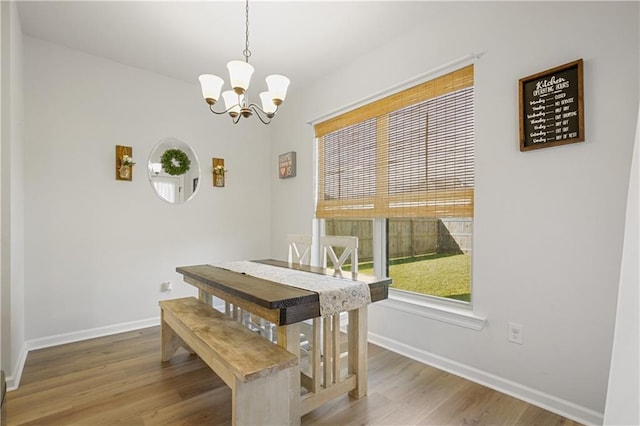 dining space featuring wood-type flooring and a chandelier