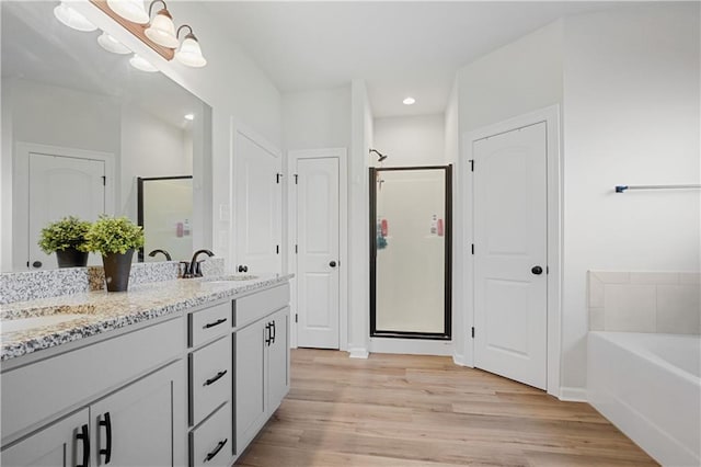 bathroom with vanity, separate shower and tub, and hardwood / wood-style flooring