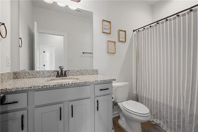 bathroom featuring hardwood / wood-style floors, curtained shower, vanity, and toilet