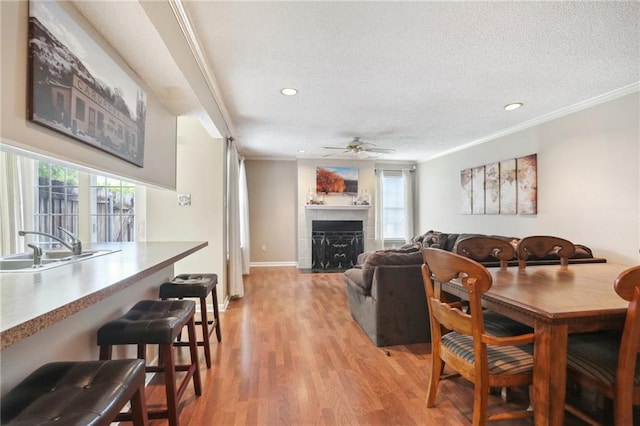 living room featuring a textured ceiling, a fireplace, plenty of natural light, and light hardwood / wood-style floors